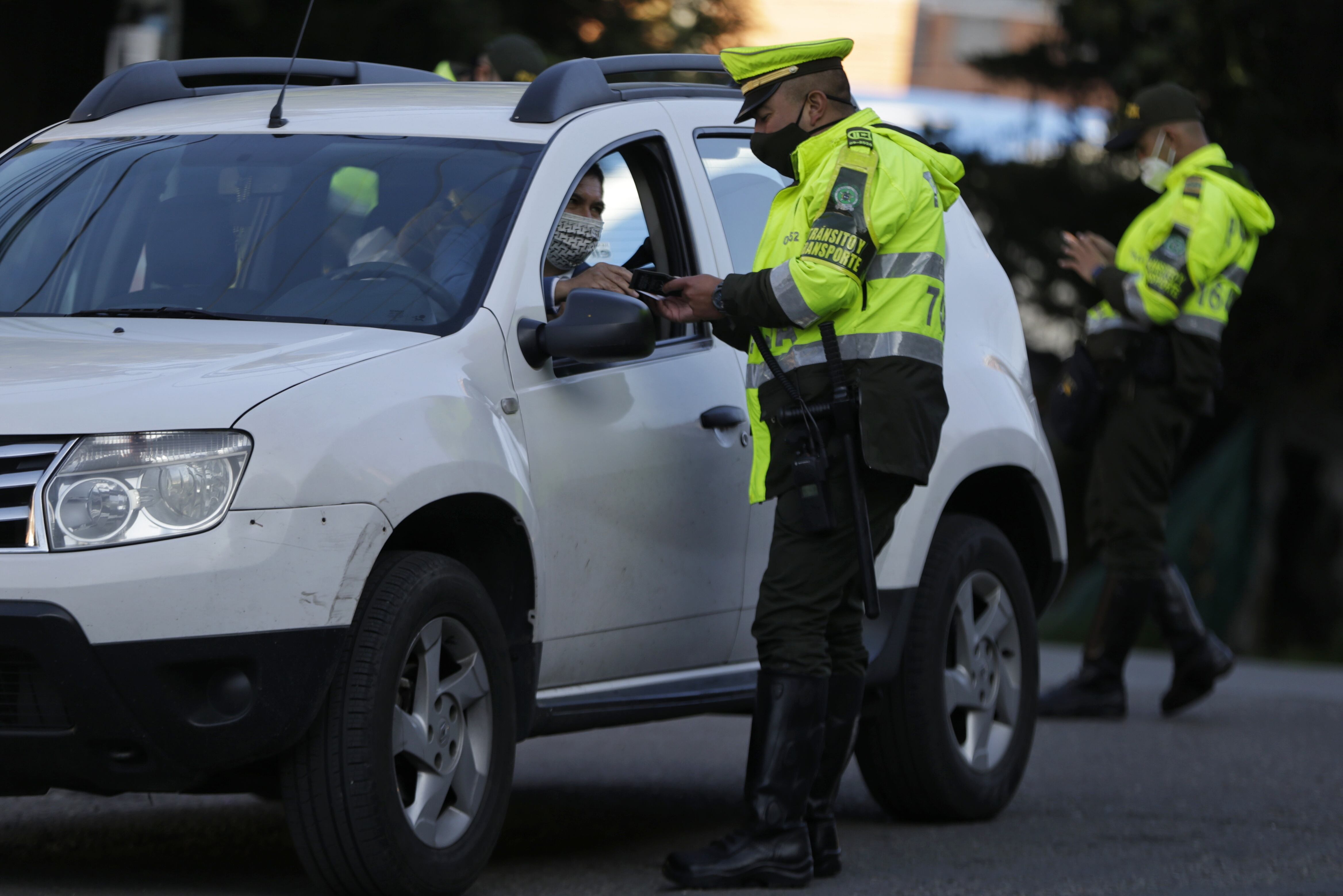 Policía de tránsito revisando papeles a un conductor (Colprensa)