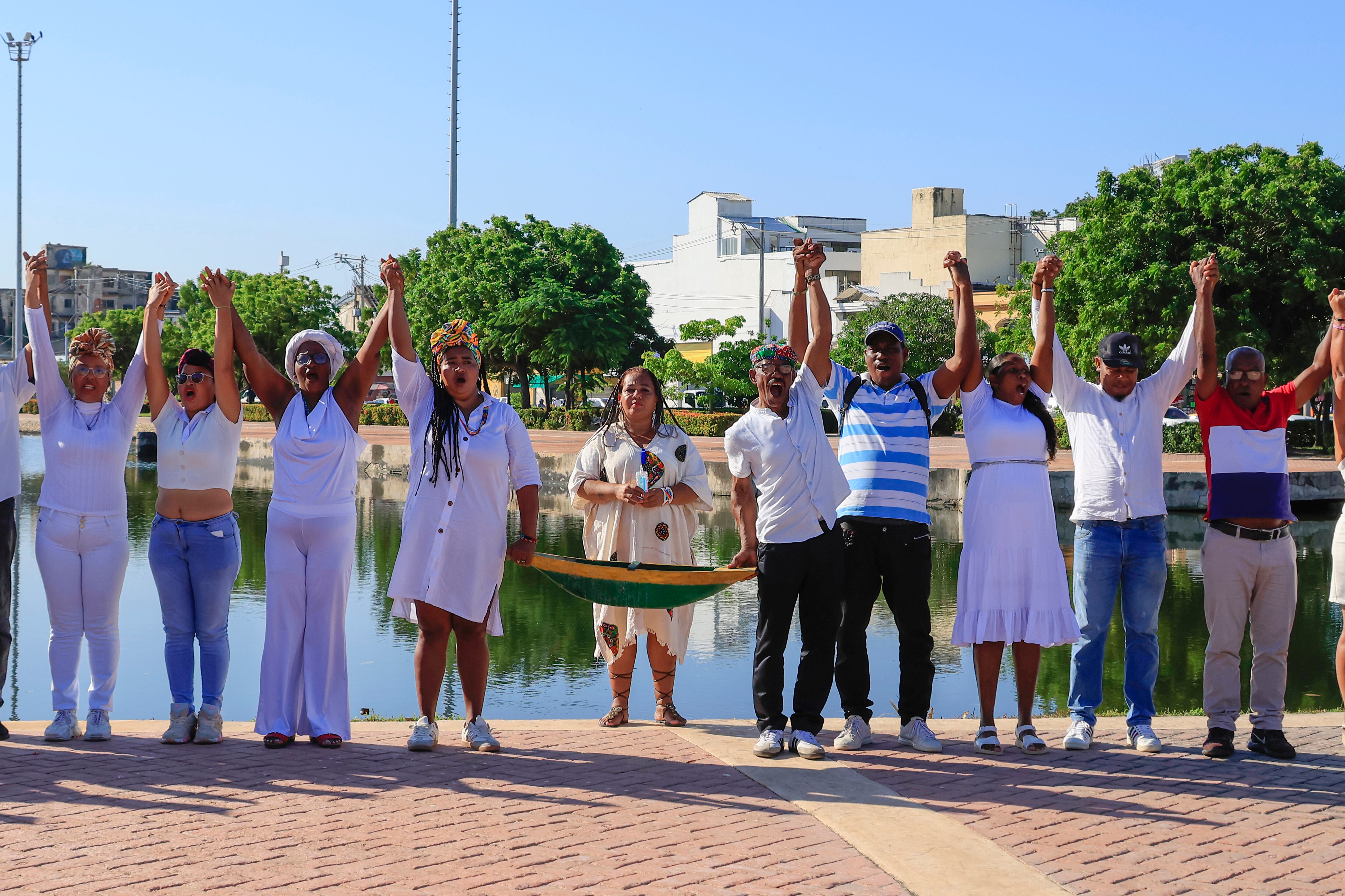 Personas participan en un acto simbólico este viernes, en Cartagena (Colombia). La JEP acreditó como víctima del conflicto armado en Colombia al territorio del Canal del Dique, un cuerpo de agua situado en el norte del país donde fueron arrojadas numerosas personas asesinadas principalmente por paramilitares. Foto: EFE/Ricardo Maldonado Rozo