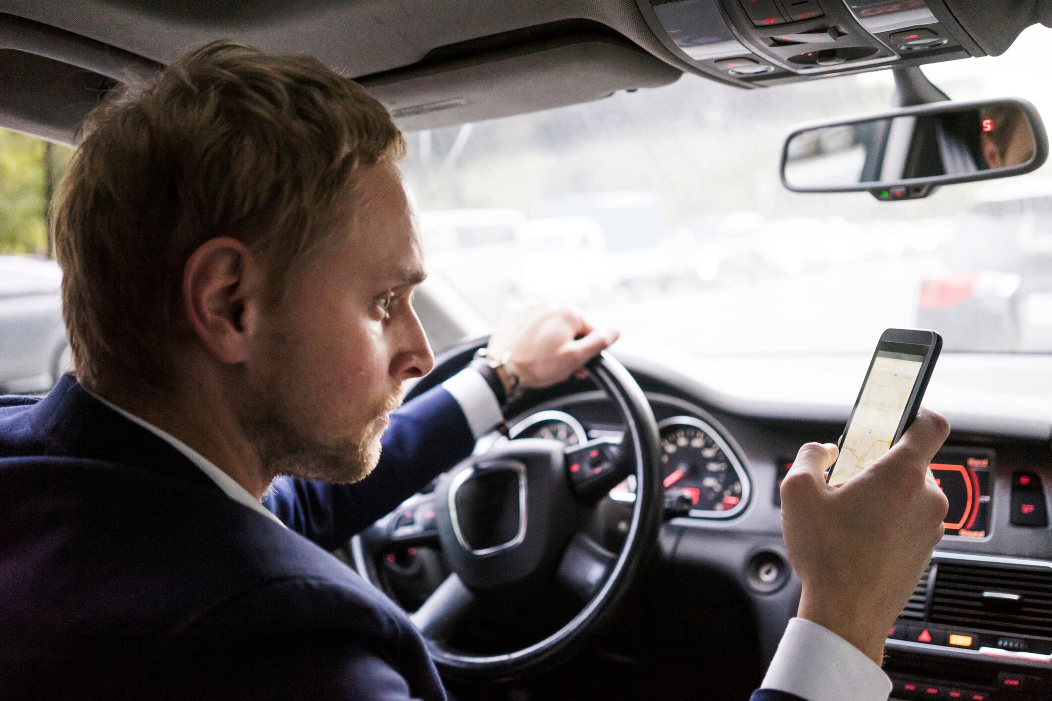 Hombre usando el celular mientras conduce. Foto: Getty Images.