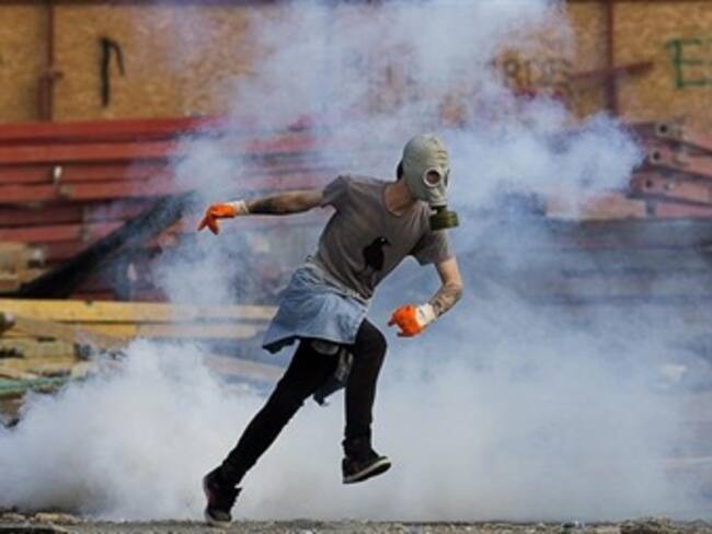 Un manifestante huye de una bomba de gas lacrimógeno durante los disturbios en la plaza Taksim en Estambul. Foto: EFE.