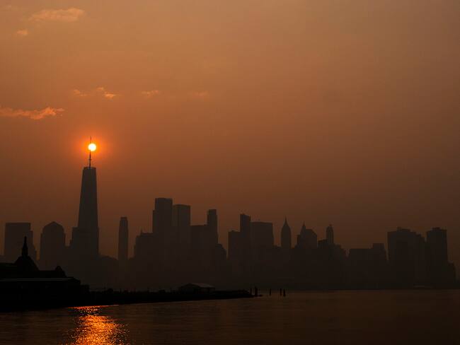 El sol sale detrás del One World Trade Center, mientras que el humo de los incendios forestales de Canadá cubre el distrito de Manhattan el 8 de junio de 2023 en Nueva Jersey. (Foto de Eduardo Muñoz Álvarez/Getty Images)