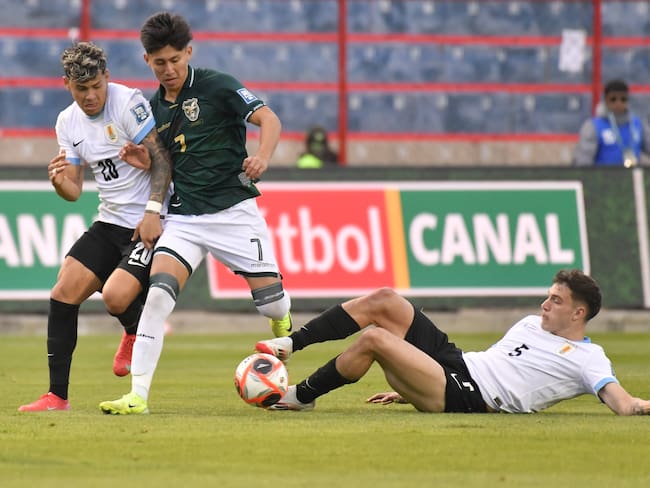 AMDEP3986. EL ALTO (BOLIVIA), 25/03/2025.- Miguel Terceros (c) de Bolivia disputa un balón con Maximiliano Araújo (i) y Manuel Ugarte de Uruguay este martes, en un partido de las eliminatorias sudamericanas para el Mundial de 2026 entre las selecciones de Bolivia y Uruguay en el estadio Municipal de El Alto, en la ciudad de El Alto (Bolivia). EFE/ Jorge Abrego