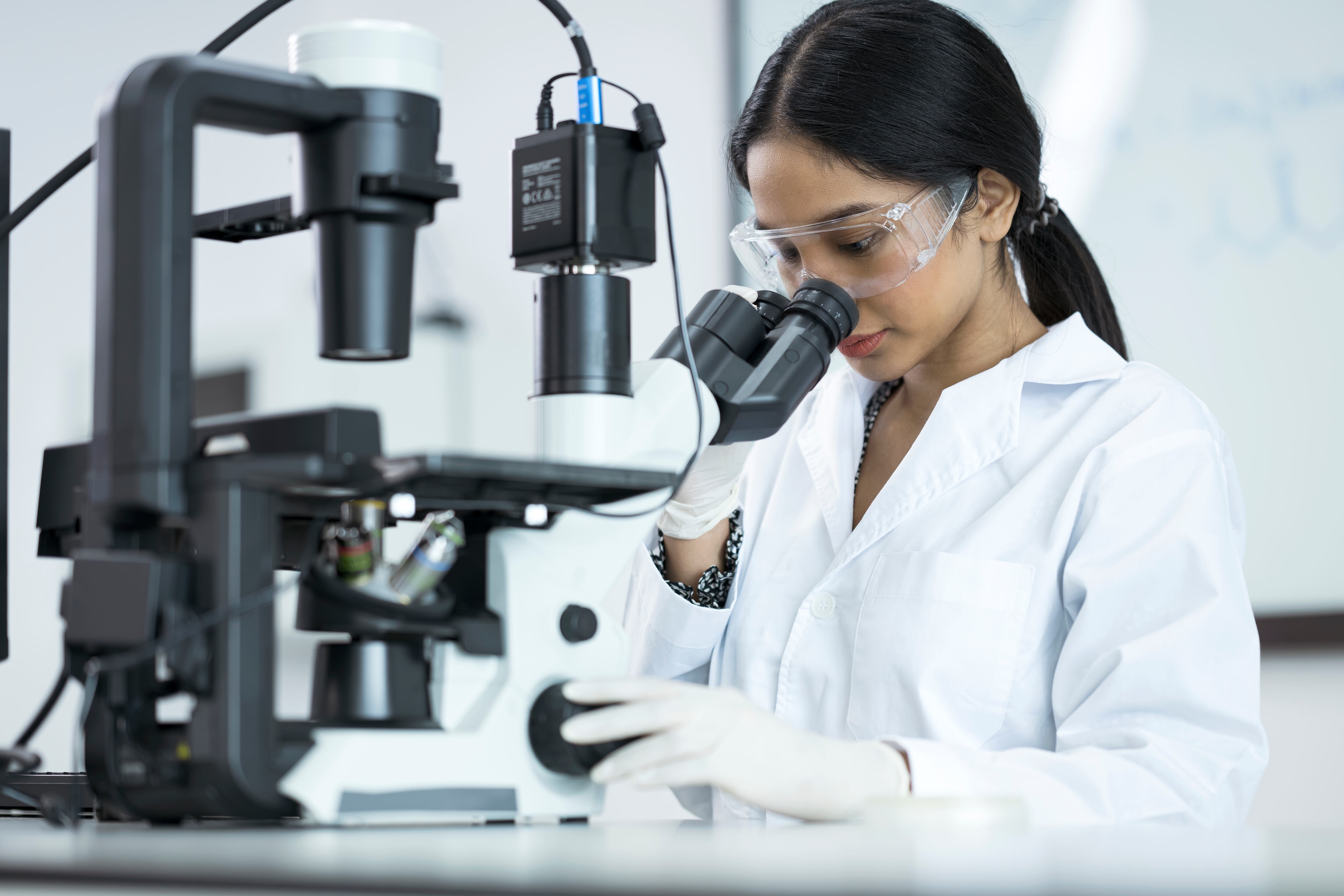 Estudiante de bacteriología mirando a través de un microscópico mientras examina algunas muestras / Foto: GettyImages
