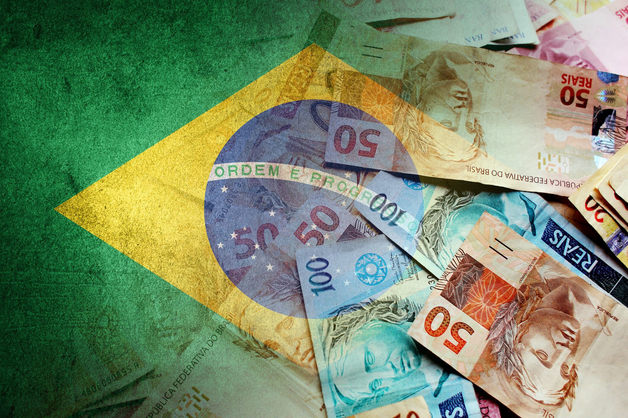 Brazilian reais cash bills and flag of Brazil (economy, finance, business, inflation, crisis)