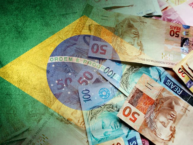 Brazilian reais cash bills and flag of Brazil (economy, finance, business, inflation, crisis)