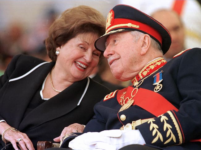 Santiago, CHILE:  (FILE) Picture taken 10 March 1998 of Chile&#039;s former dictator (1973-90) general Augusto Pinochet (R) listening to his wife Lucia Hiriart during the ceremony marking his retirement from the army command at the Military Academy in Santiago. Pinochet, 91, died 10 December, 2006 at the Military Hospital in Santiago, where he was admitted a week ago following a heart attack. Accused of fraud and human rights abuses during his regime, Pinochet was first ordered under house arrest in late October on other charges only to be released on parole a few days later in deference to his advanced age and ill health.  AFP PHOTO/CRIS BOURONCLE  (Photo credit should read CRIS BOURONCLE/AFP via Getty Images)