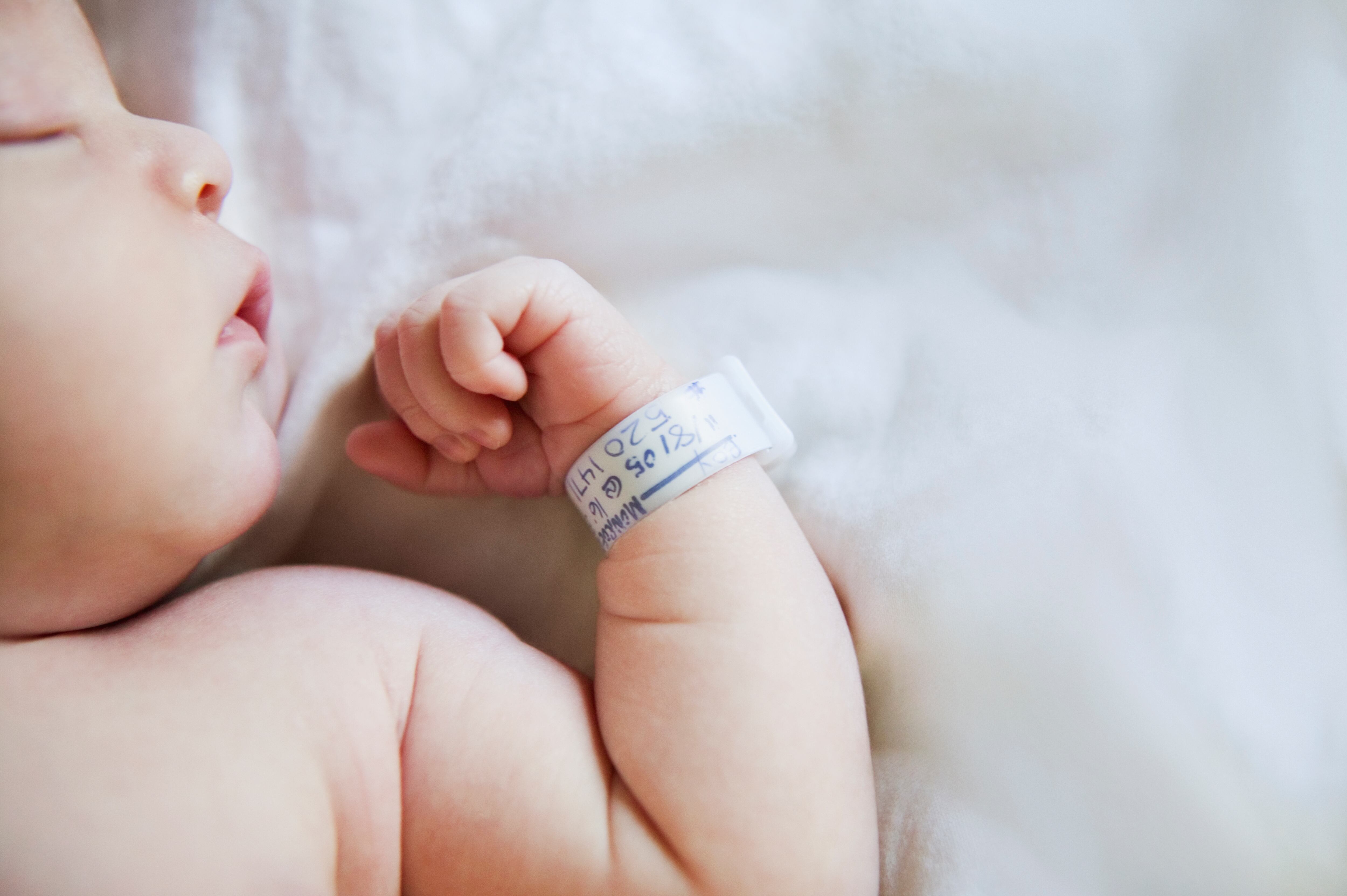 Bebé recién nacido con un brazalete durmiendo en un hospital / Foto: GettyImages