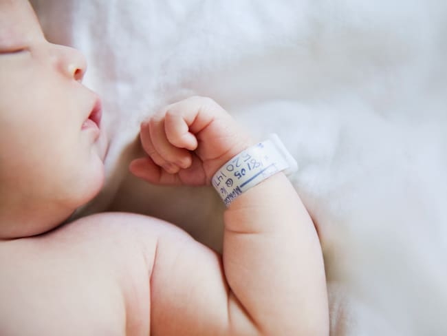 Bebé recién nacido con un brazalete durmiendo en un hospital / Foto: GettyImages