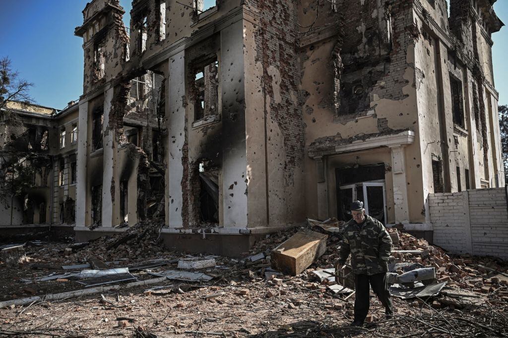 An eldery man walks in front of a destroyed school in Kharkiv on March 25, 2022, during Russia's military invasion launched on Ukraine. - Russian strikes targeting a medical facility in Kharkiv on March 25, 2022, killed at least four civilians and wounded several others, Ukrainian officials said. (Photo by Aris Messinis / AFP) (Photo by ARIS MESSINIS/AFP via Getty Images)
