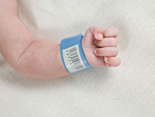 Bebé recién nacido en el hospital con su manilla de registro (Getty Images)