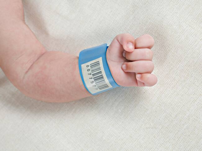 Bebé recién nacido en el hospital con su manilla de registro (Getty Images)