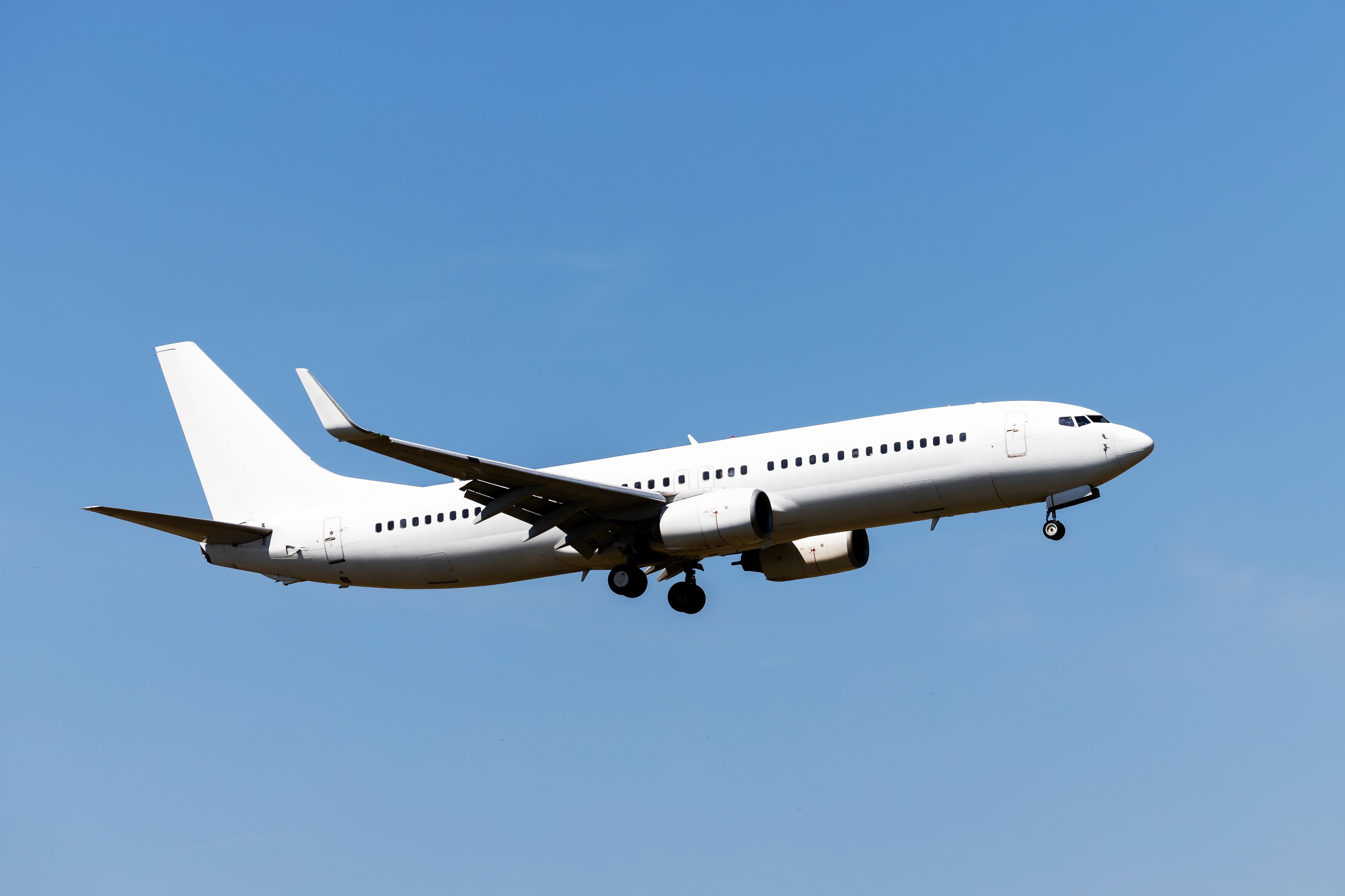 White passenger aircraft in the blue sky