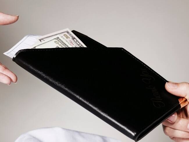 Foto ilustrativa de un sujeto pagando la cuenta en un restaurante. Foto: Getty Images