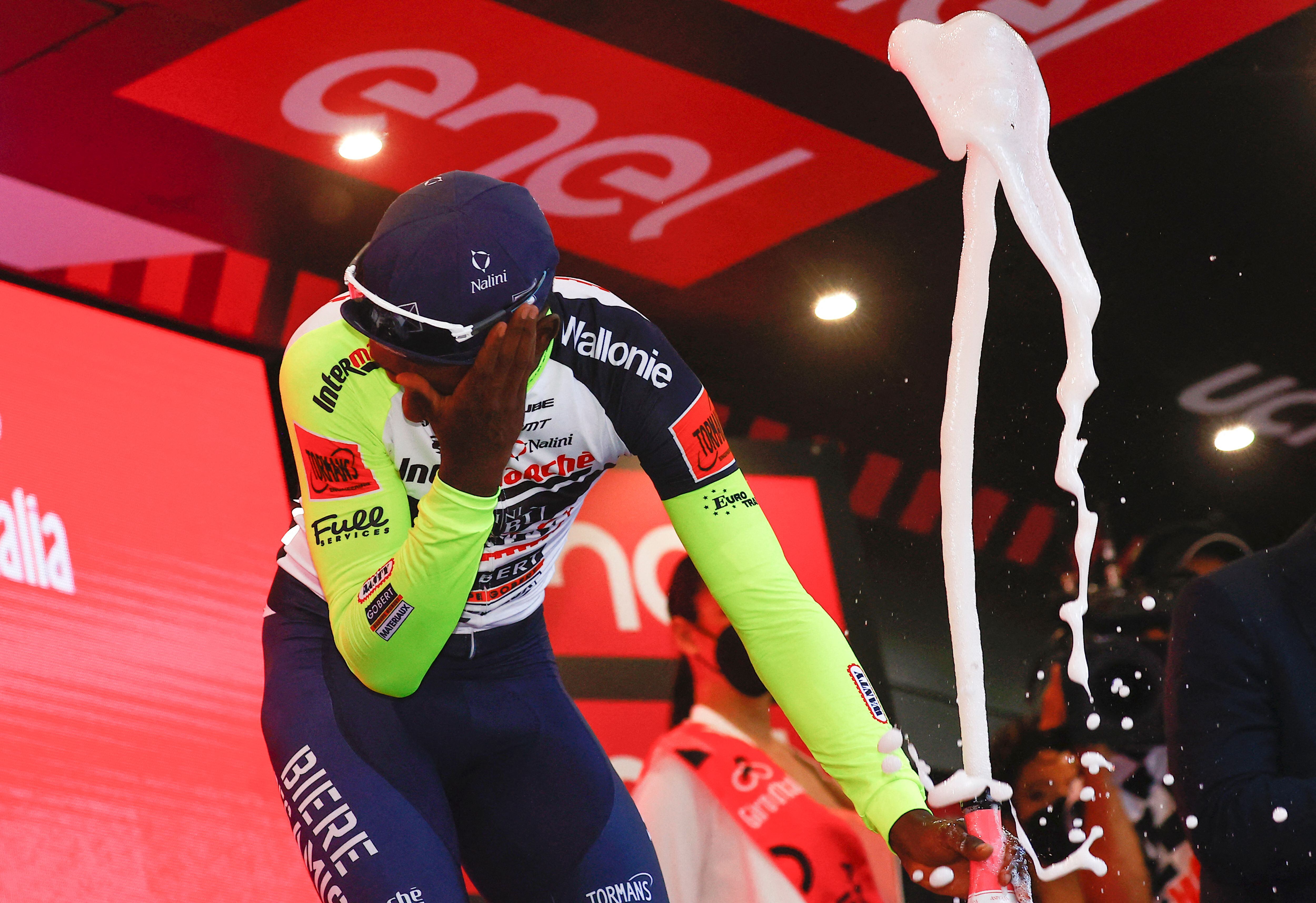 Team Wanty's Eritrean rider Biniam Girmay Hailu reacts after popping a champagne cork as he celebrates on the podium after winning the 10th stage of the Giro d'Italia 2022 cycling race, 196 kilometers between Pescara and Jesi, central Italy, on May 17, 2022. - History-maker Biniam Girmay pulled out of the Giro d'Italia before the start of the 11th stage, with an eye injury he suffered when he was struck by a champagne cork. (Photo by Luca Bettini / AFP) (Photo by LUCA BETTINI/AFP via Getty Images)