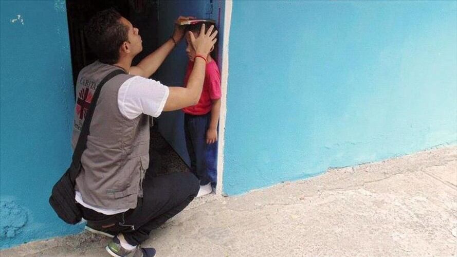 Un miembro de la ONG Caritas evaluando el estado de salud de un niño en Venezuela. Foto: Foto - ONG Caritas Venezuela