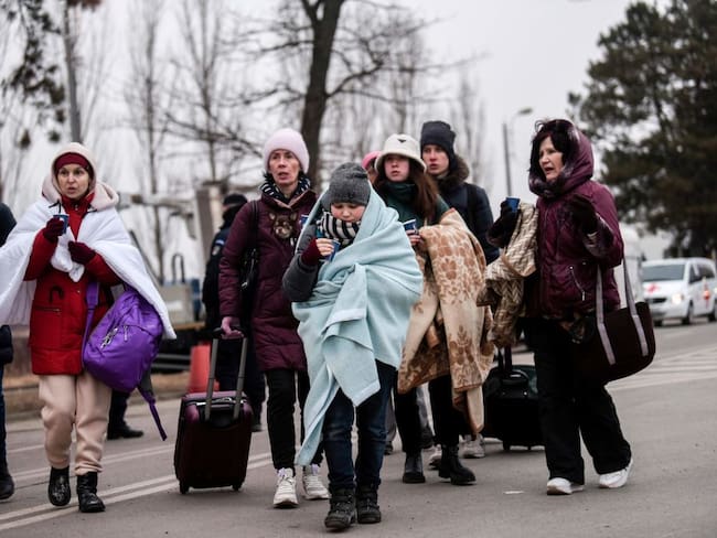 Ukrainian evacuees walk at the Ukrainian-Romanian border in Siret, northern Romania, on March 16, 2022. - More than three million people have fled Ukraine since the start of the invasion, the UN migration agency IOM says. Around half are minors, says the UN children&#039;s agency. (Photo by Armend NIMANI / AFP) (Photo by ARMEND NIMANI/AFP via Getty Images)