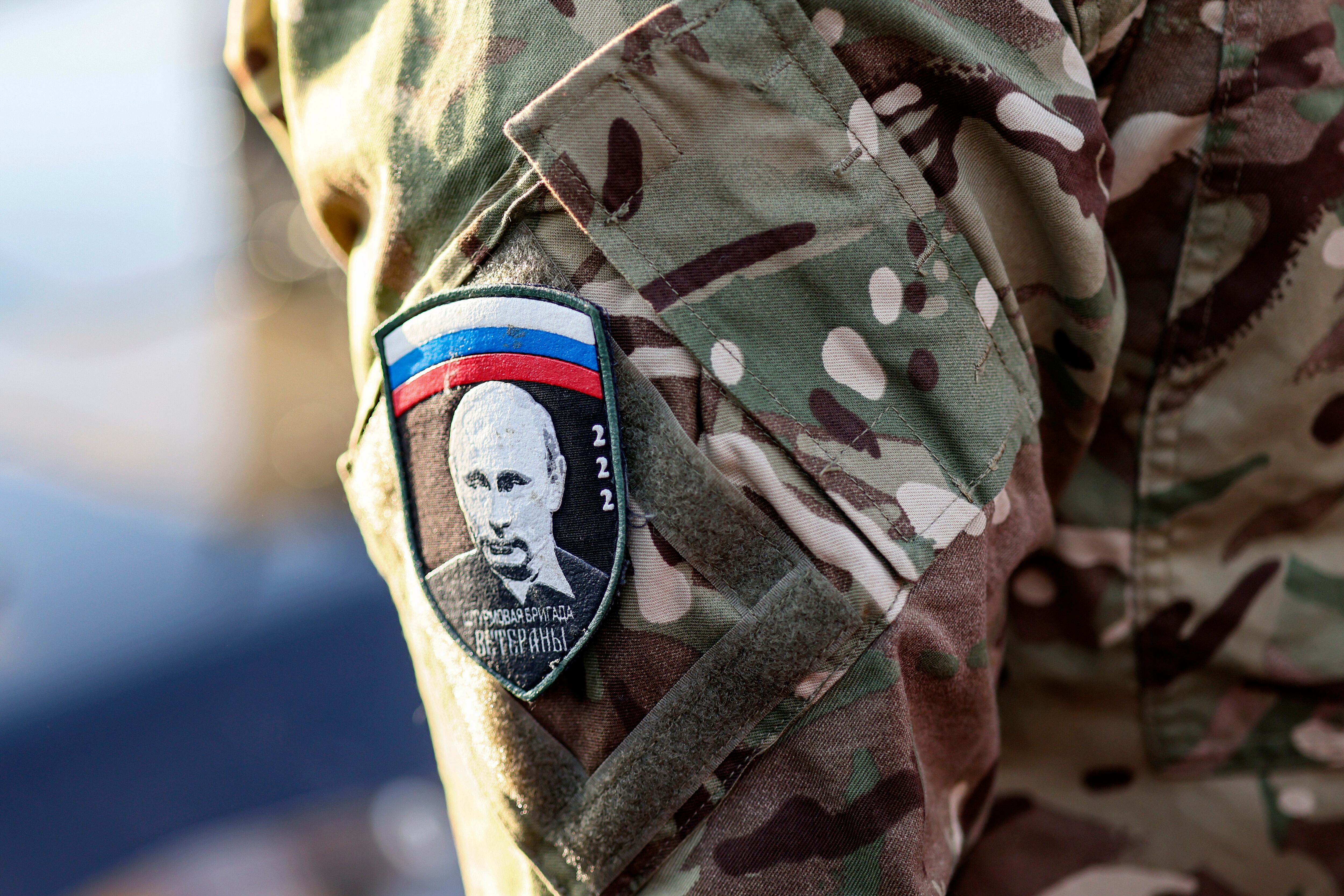 MOSCÚ (Federación Rusa), 26/02/2025.- Un soldado con un galón con la imagen del presidente ruso, Vladímir Putin, en el que se lee «Veteranos de la Brigada de Asalto», asiste a un acto de envío de ayuda a los militares en las zonas de conflicto con Ucrania, en la Granja Estatal Lenin.