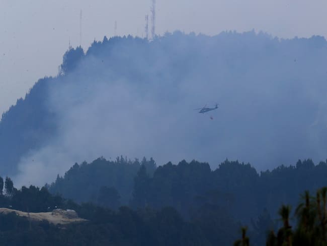 BOG400. BOGOTÁ (COLOMBIA), 27/01/2024.- Un helicóptero combate hoy un incendio forestal en el cerro El Cable, en Bogotá (Colombia). Frente a los incendios que golpean a la capital colombiana, el alcalde Carlos Fernando Galán anunció medidas como una alerta zonal por deterioro de la calidad del aire en el suroccidente de la ciudad, así como extender la medida de pico y placa -que restringe el tránsito de vehículos- a los sábados. EFE/ Carlos Ortega