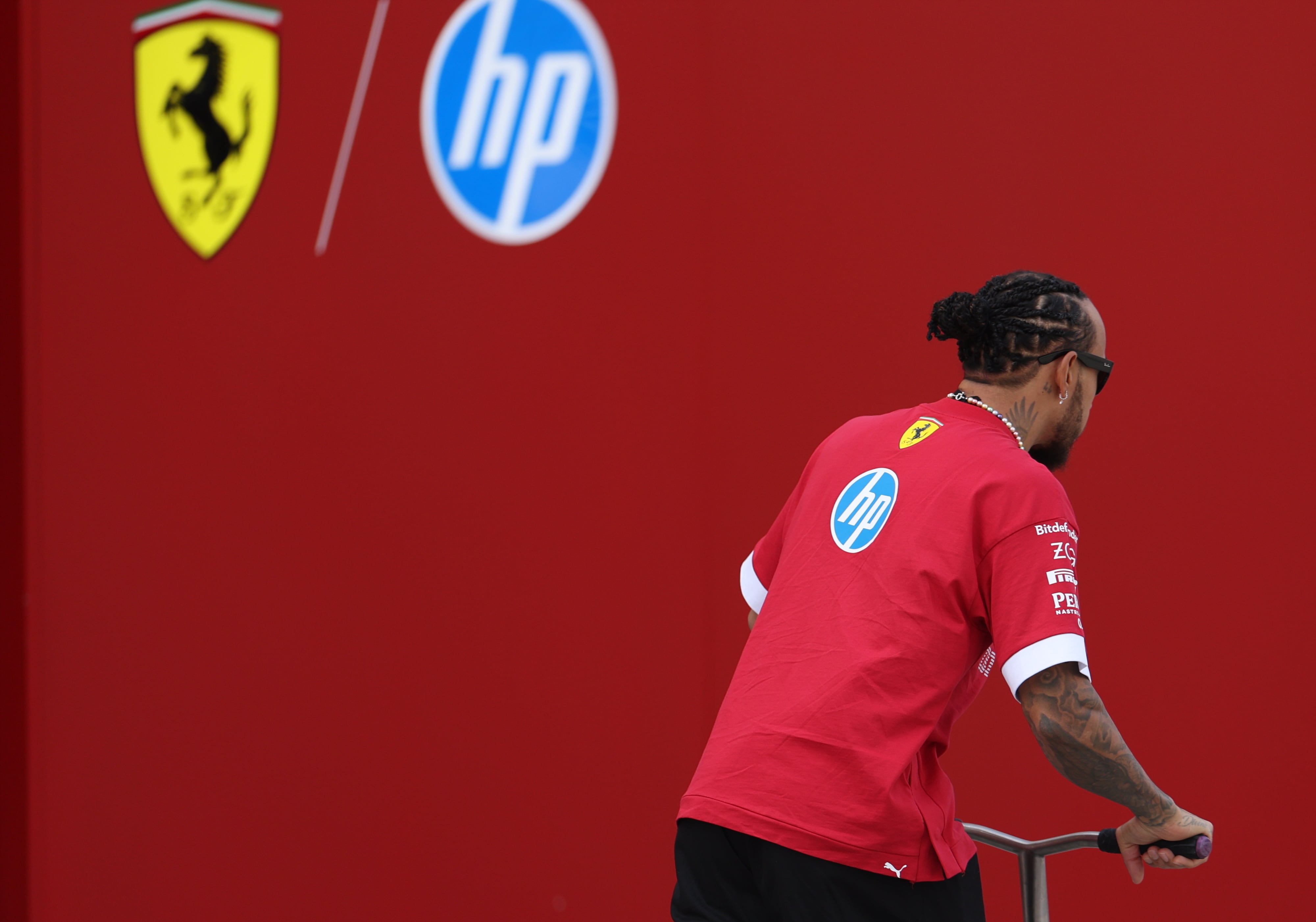 SAKHIR (Baréin), 28/02/2025.- El piloto británico de la Scuderia Ferrari Lewis Hamilton pasea en scooter por el paddock durante los entrenamientos de pretemporada de Fórmula 1.