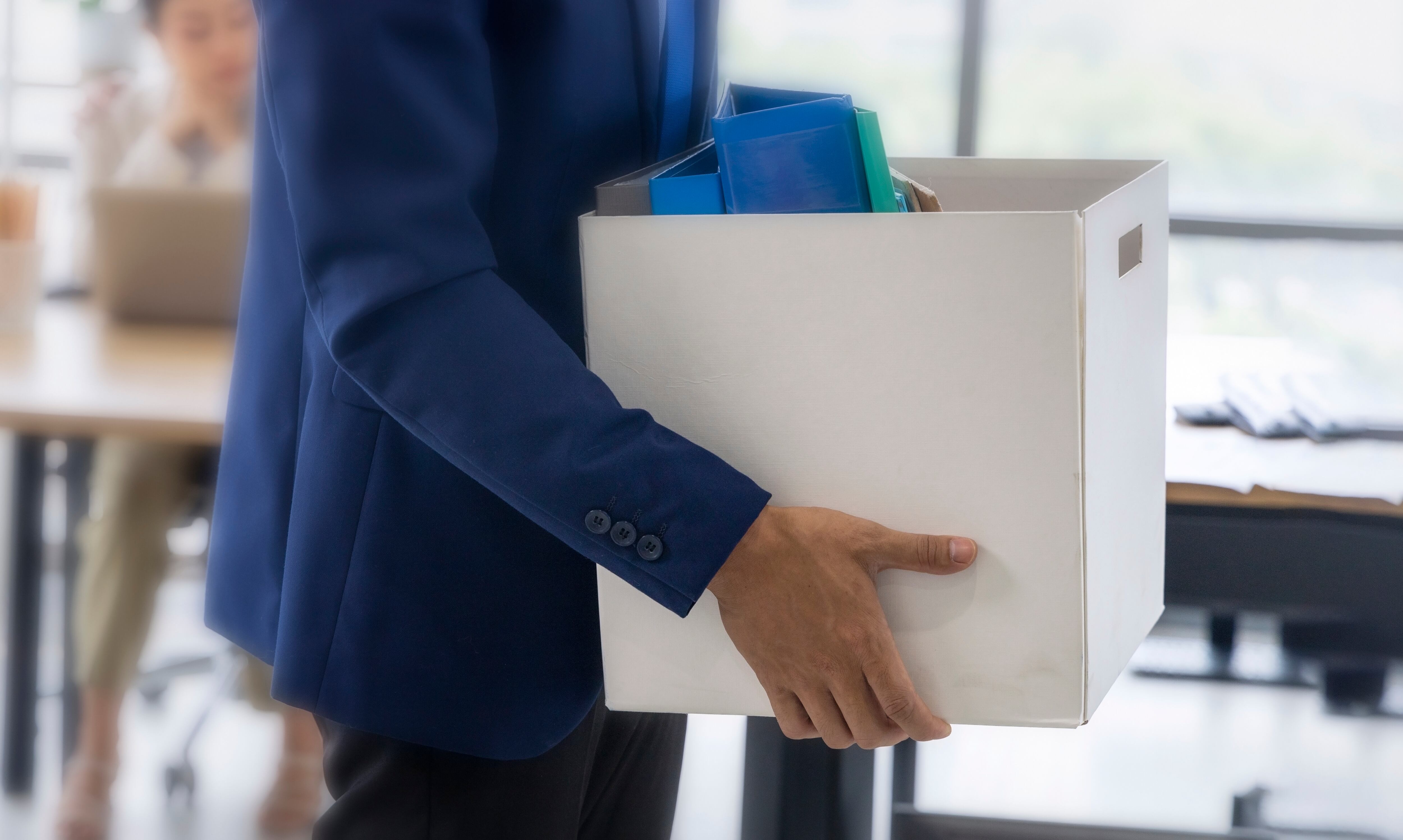 business concept : An unemployed with her cardboard box walking out of the work office