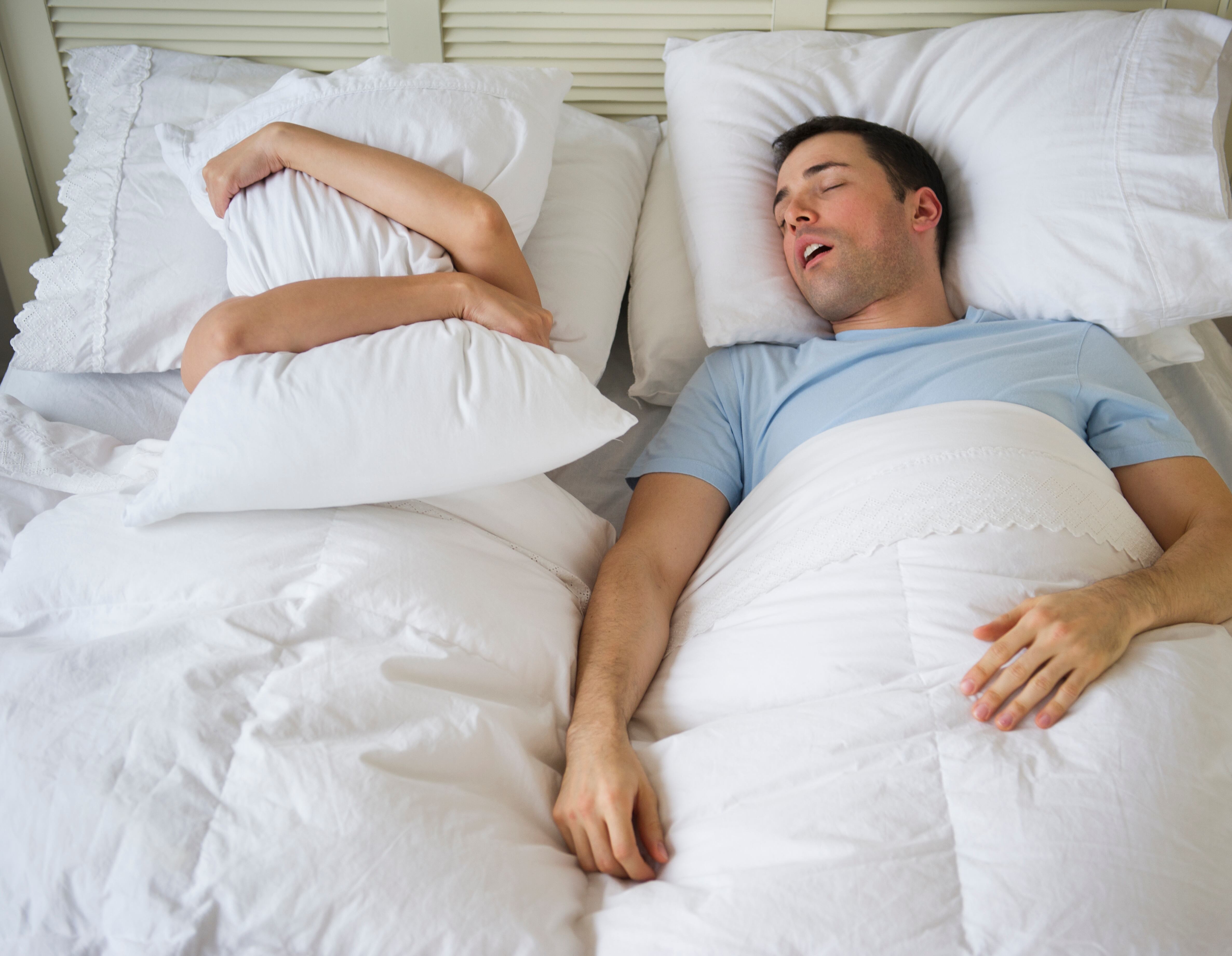 Hombre roncando mientras su pareja no puede dormir a causa de ello. (Foto vía Getty Images)