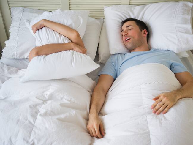 Hombre roncando mientras su pareja no puede dormir a causa de ello. (Foto vía Getty Images)