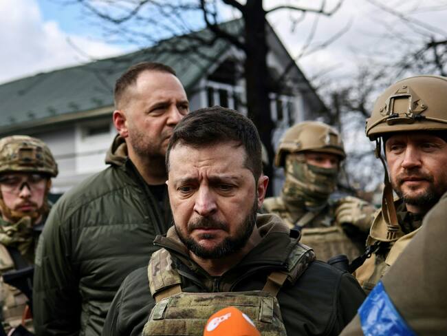 Ukainian President Volodymyr Zelensky (C) speaks to the press in the town of Bucha, northwest of the Ukrainian capital Kyiv, on April 4, 2022. - Ukraine's President Volodymyr Zelensky said on April 3, 2022 the Russian leadership was responsible for civilian killings in Bucha, outside Kyiv, where bodies were found lying in the street after the town was retaken by the Ukrainian army. (Photo by RONALDO SCHEMIDT / AFP) (Photo by RONALDO SCHEMIDT/AFP via Getty Images)
