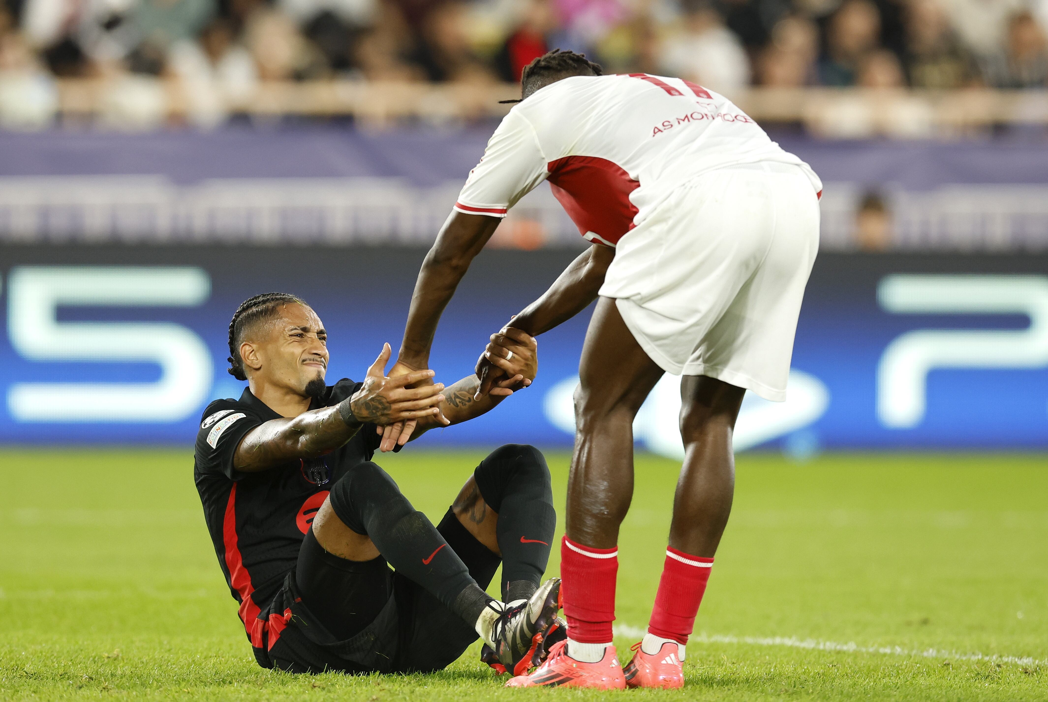 Monaco (Monaco), 19/09/2024.- Wilfried Singo (R) of Monaco helps Raphinha of Barcelona to get up on his feet during the UEFA Champions League match between AS Monaco and Barcelona in Monaco, 19 September 2024.