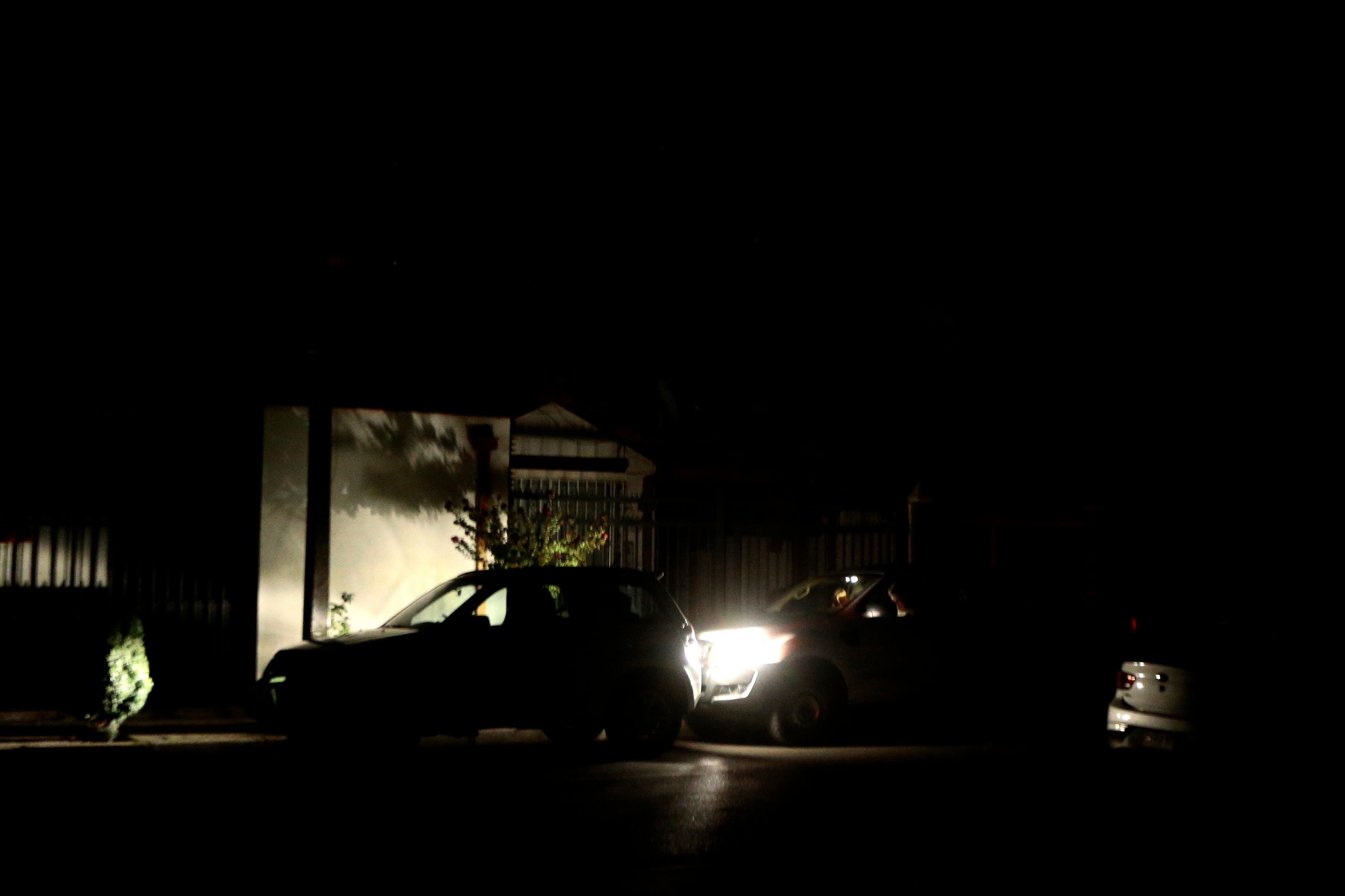 AME3599. SANTIAGO (CHILE), 25/02/2025.- Vehículos iluminan una zona sin energía este martes, en Santiago (Chile). Chile se prepara para pasar una noche sin suministro eléctrico después de que fallaran los tres intentos por reparar el corte de energía ocurrido en la tarde de este martes y que afecta al 99 % del país. EFE/ Osvaldo Villarroel