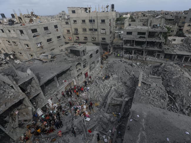 Palestinos buscan cadáveres y supervivientes entre los escombros de una casa destruida tras un ataque aéreo israelí en el campo de refugiados de Al Nusairat, al sur de la Franja de Gaza, este sábado. Foto: EFE/MOHAMMED SABER.