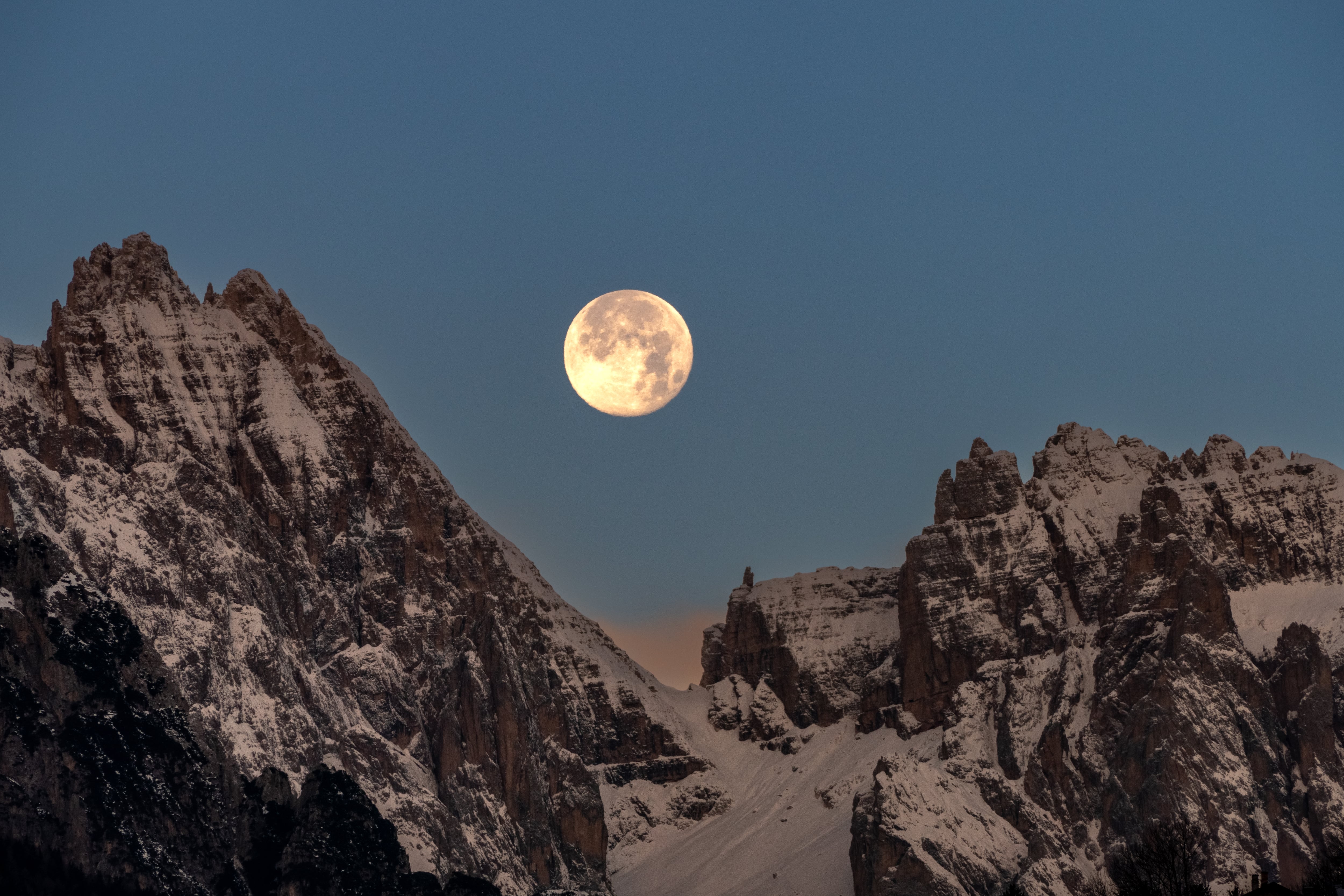 Vista panorámica de la Luna llena en medio de unas montañas nevadas (Foto vía GettyImages)