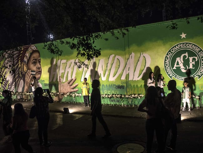 Locals pose for photos after the presentation of a mural in honour of the victims and survivors of Lamia flight 2933 on the first anniversary of the plane crash in Colombia that wiped out the Chapecoense Brazilian football club, in Medellin next to the Atanasio Girardot stadium, Colombia, on November 29, 2017. The plane was flying Chapecoense to Medellin to take on Atletico Nacional in the Copa Sudamericana finals - the biggest and most unexpected game in the Brazilian team&#039;s history. When the plane ran out of fuel and went down in inhospitable mountains near its destination, 71 of the 77 aboard died, including 19 players. / AFP PHOTO / JOAQUIN SARMIENTO        (Photo credit should read JOAQUIN SARMIENTO/AFP via Getty Images)