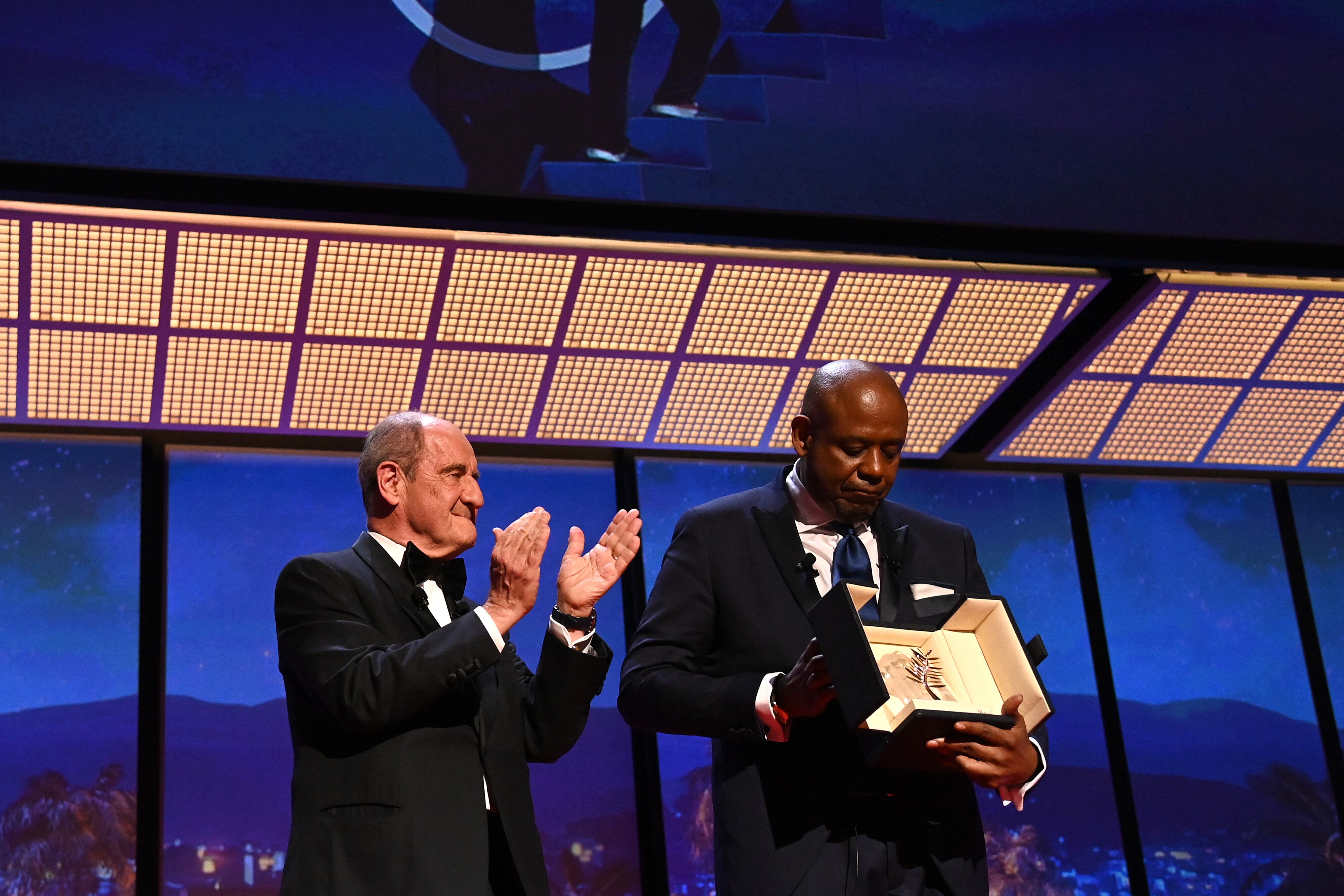CANNES, FRANCE - MAY 17: Forest Whitaker (R) receives The Honorary Palme d'Or from Pierre Lescure (L) during the opening ceremony for the 75th annual Cannes film festival at Palais des Festivals on May 17, 2022 in Cannes, France. (Photo by Pascal Le Segretain/Getty Images)