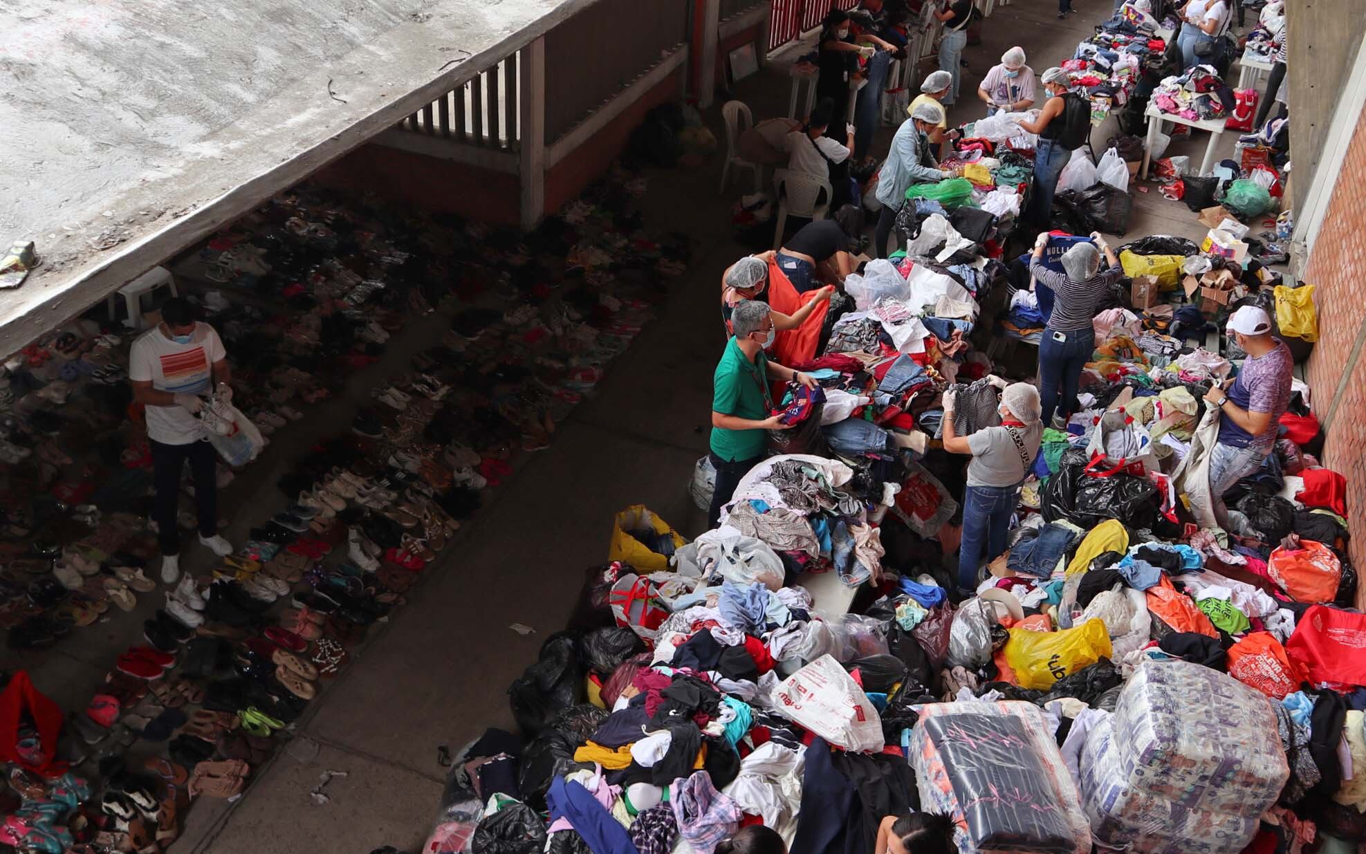 CÚCUTA (COLOMBIA), 20/01/2025.- Personas clasifican algunas prendas que fueron donadas para los desplazados por la violencia en el Catatumbo, en el estadio General Santander.