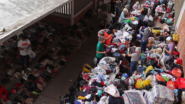 Personas clasifican algunas prendas que fueron donadas para los desplazados por la violencia en el Catatumbo. EFE/Mario Caicedo