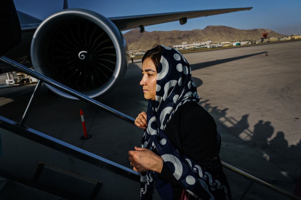 Mujer que aborda un vuelo en el aeropuerto de Kabul, Afganistán, (MARCUS YAM / LOS ANGELES TIMES)
