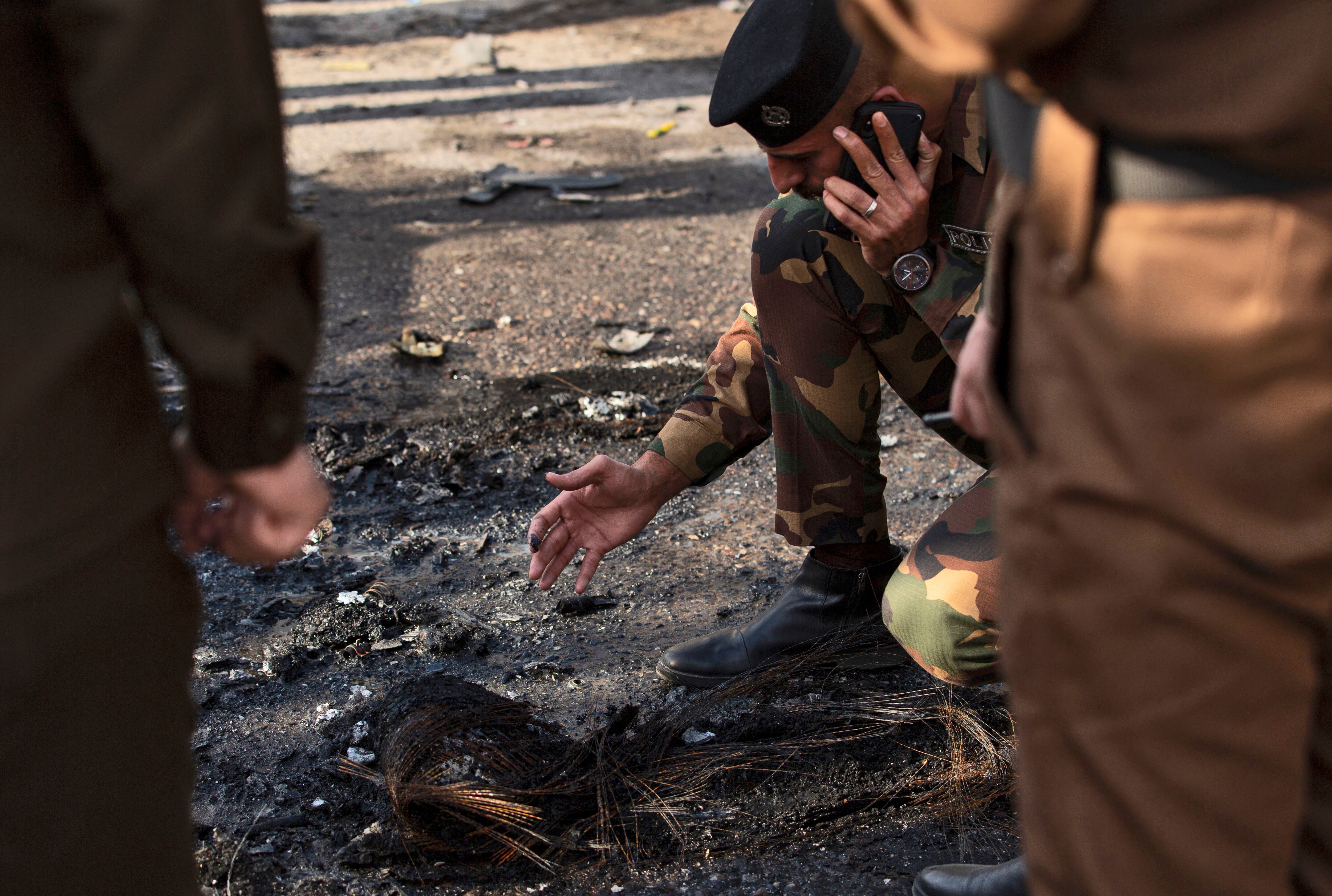EDITORS NOTE: Graphic content / A picture shows Iraqi security forces checking evidence in the southern Iraqi city of Basra after at least four civilians were killed and four more wounded in a motorcycle bombing near a hospital on December 7, 2021. (Photo by Hussein FALEH / AFP) (Photo by HUSSEIN FALEH/AFP via Getty Images)