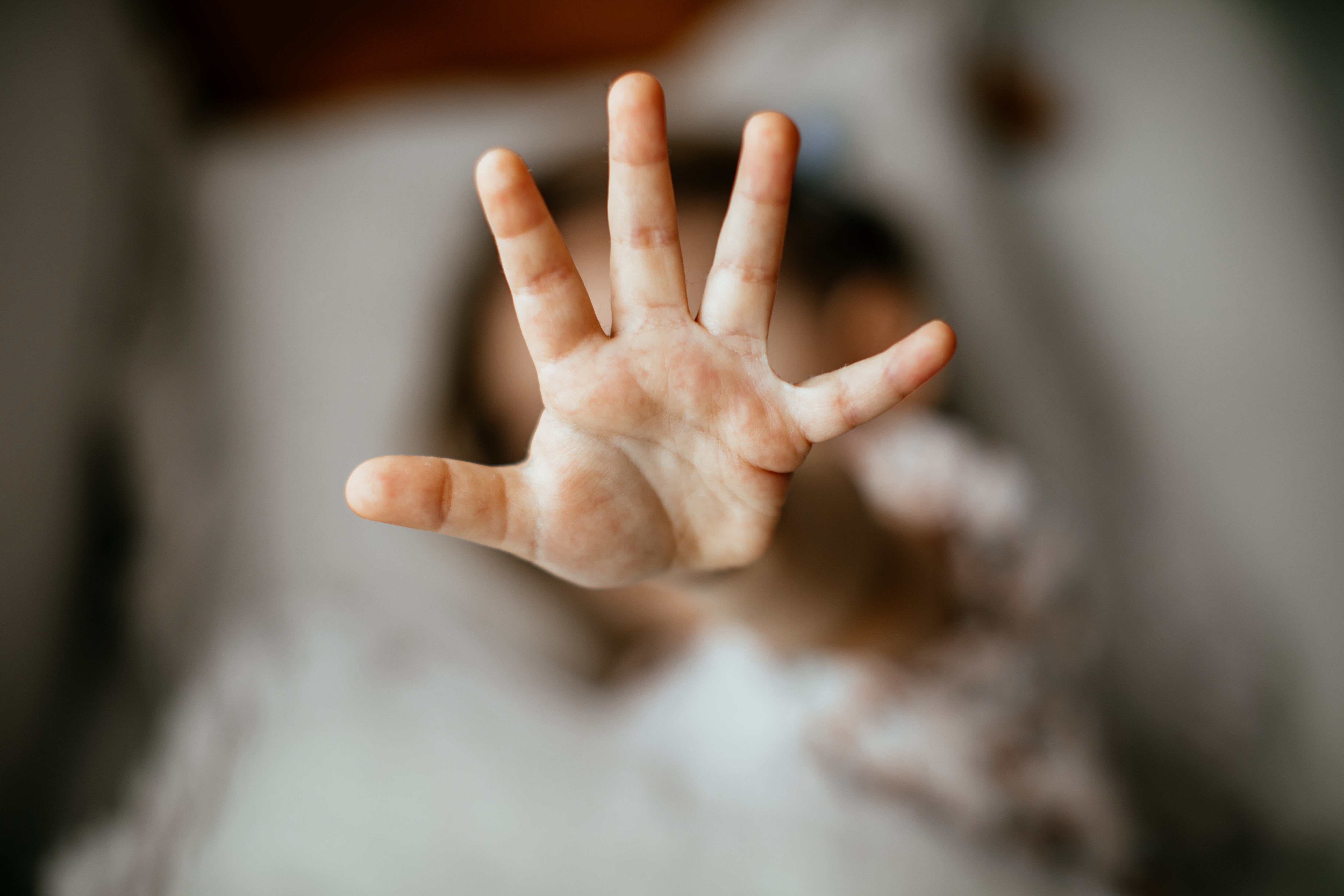 A girl showing 5 with her fingers