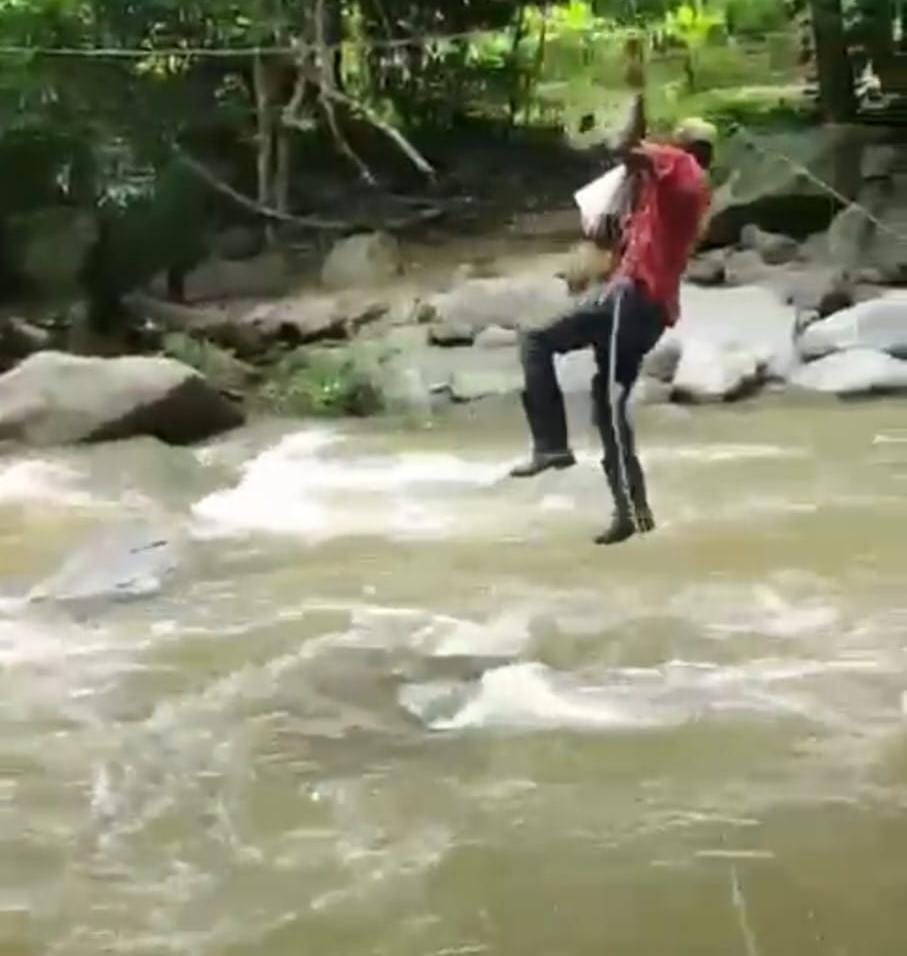 Hombre cruzando el río con un bebé/ Captura de pantalla video/ Erika López.