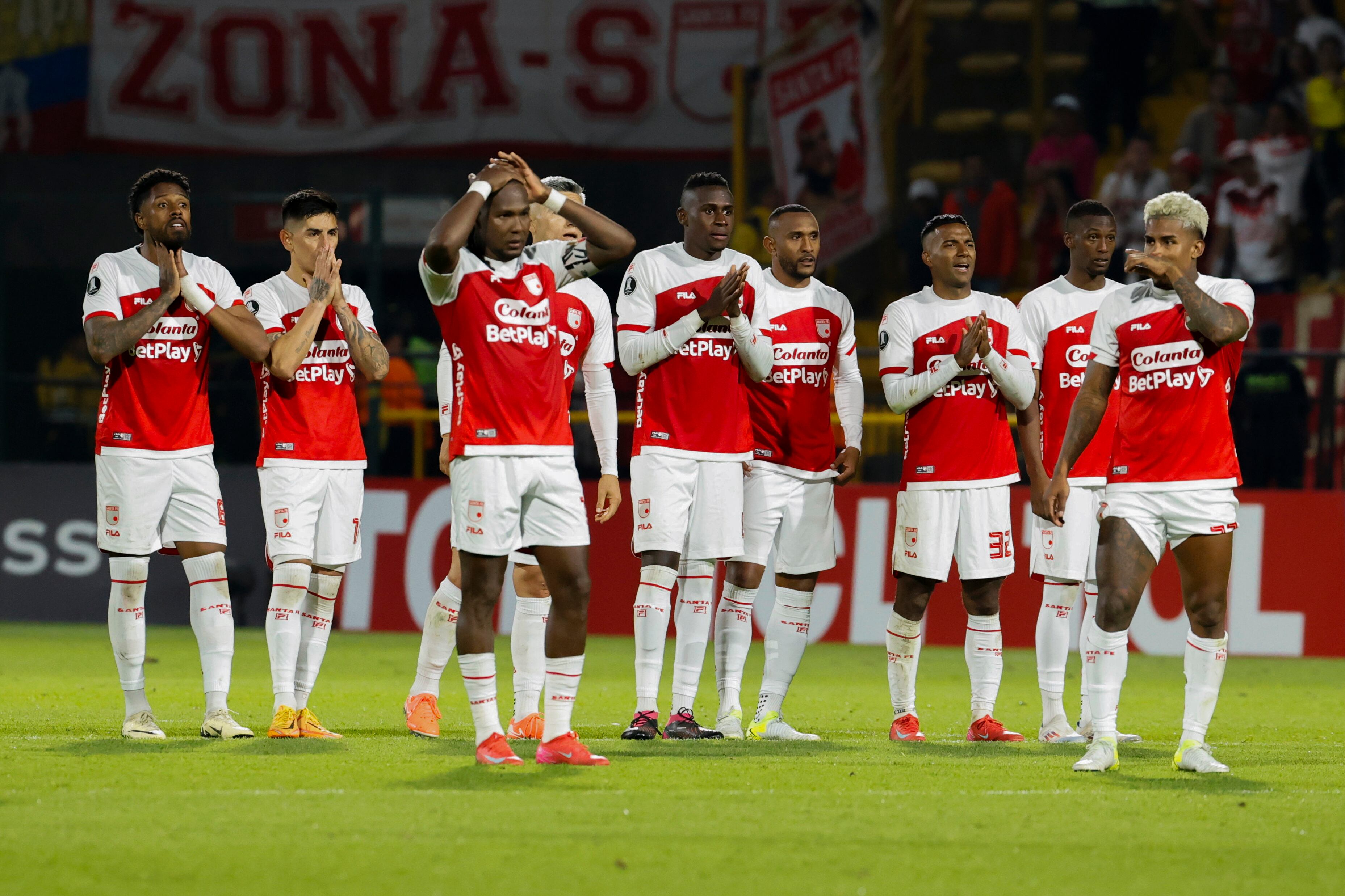Jugadores de Santa Fe reaccionan en la serie de penaltis este martes, en un partido de la segunda ronda de la Copa Libertadores entre Independiente Santa Fe e Iquique en el estadio de Techo en Bogotá (Colombia). EFE/ Mauricio Dueñas Castañeda