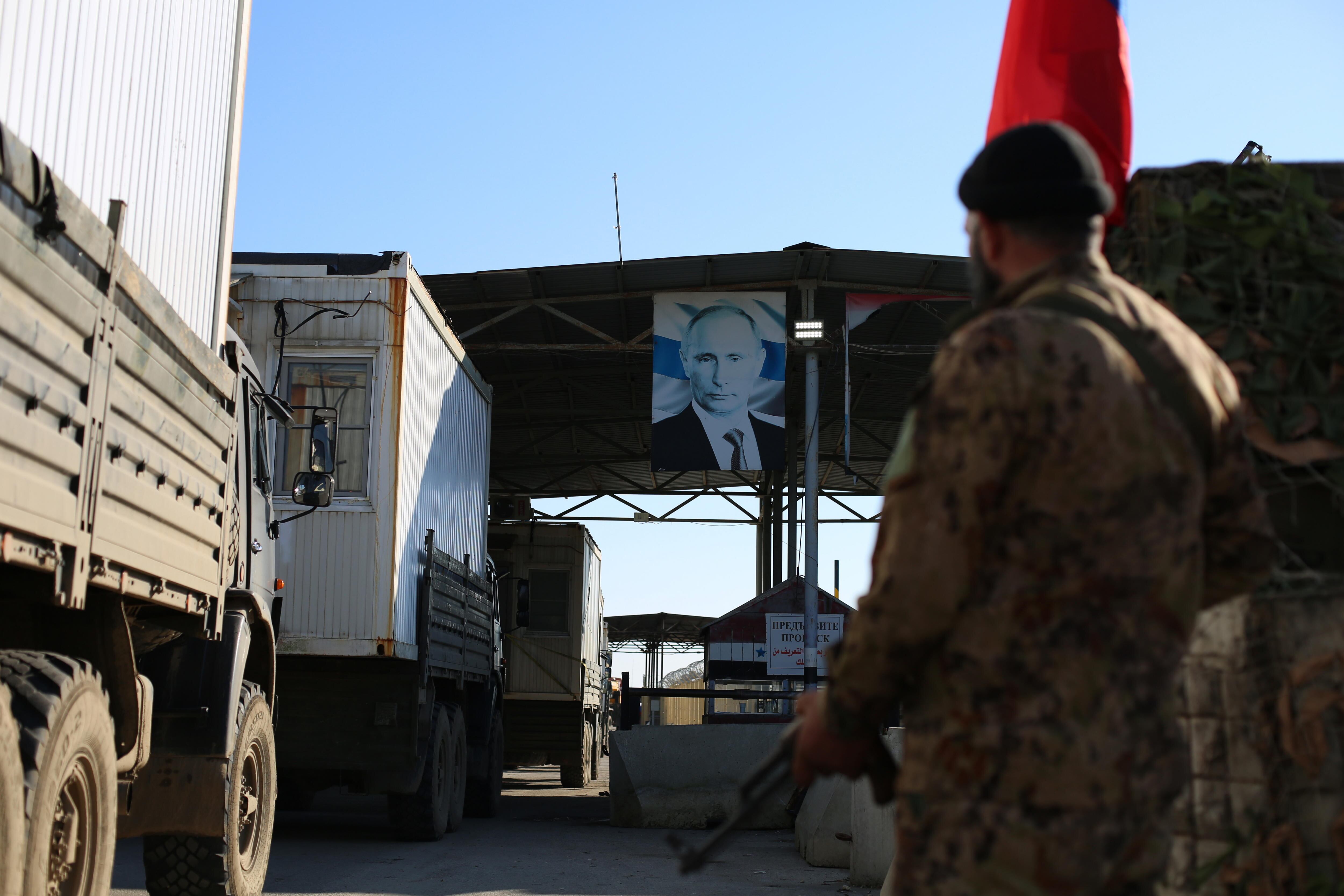 Latakia (República Árabe Siria), 02/01/2025.- Un combatiente de la oposición siria vigila la puerta principal de una base militar rusa en el aeropuerto de Hmeimim.