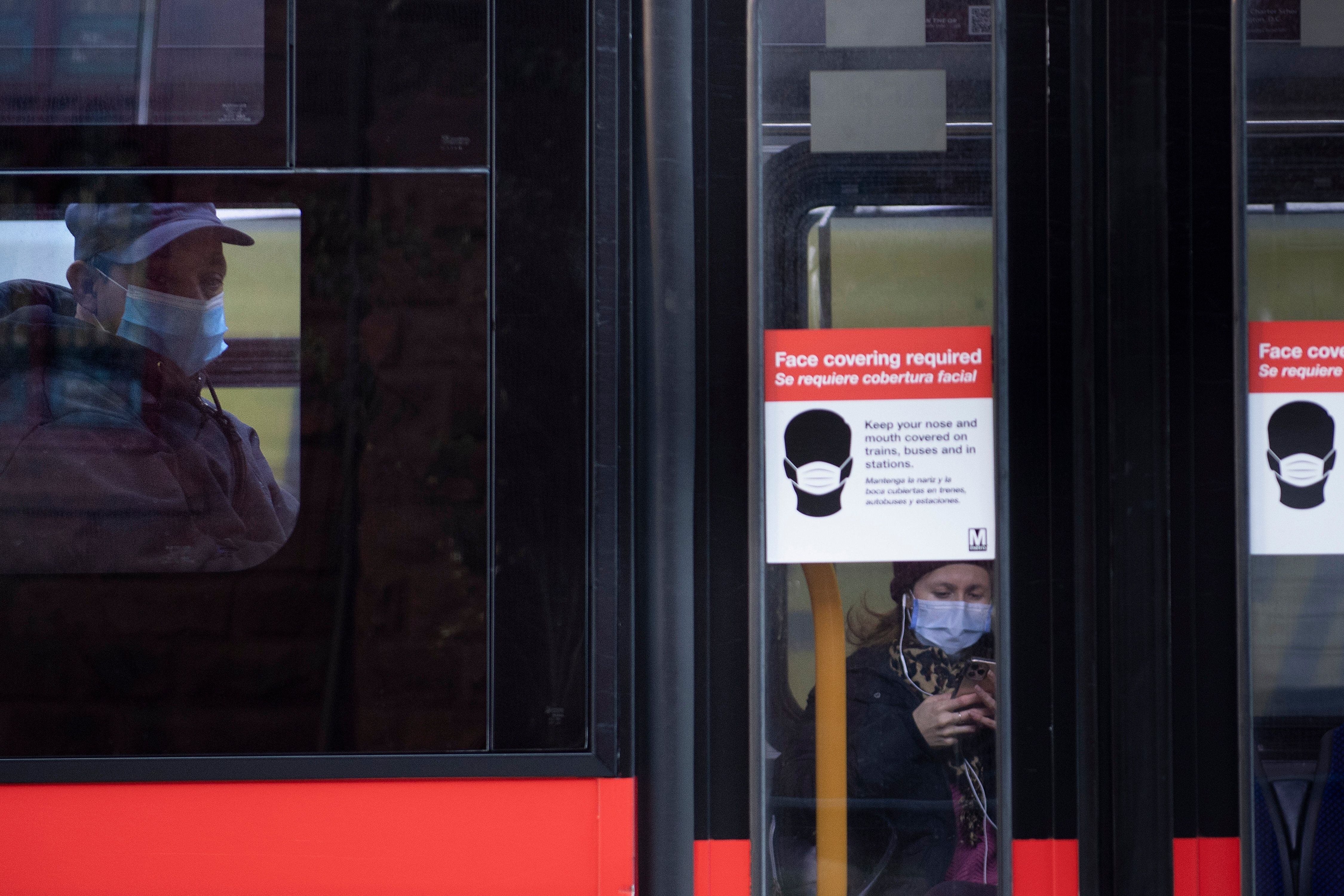 People ride the bus with masks to combat Covid-19 January 12, 2021, in Washington, DC. (Photo by Brendan Smialowski / AFP) (Photo by BRENDAN SMIALOWSKI/AFP via Getty Images)