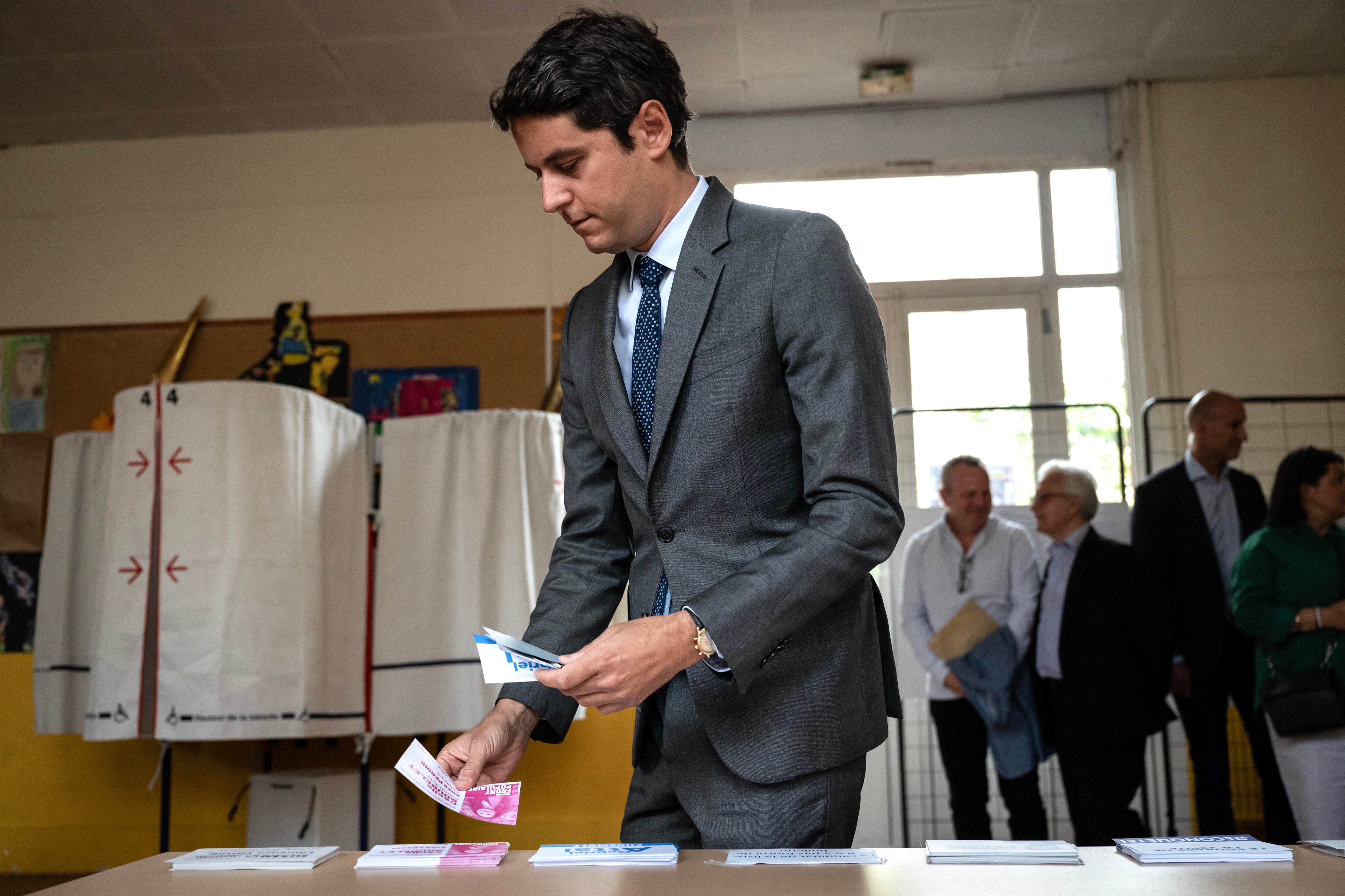 Vanves (France), 30/06/2024.- France's Prime Minister Gabriel Attal (front) takes ballots prior to casting his vote in the first round of parliamentary elections in Vanves, southwestern Paris, France, 30 June 2024. A divided France is voting in high-stakes parliamentary elections that could see the anti-immigrant and eurosceptic party of Marine Le Pen sweep to power in a historic first. The candidates formally ended their frantic campaigns at midnight on 28 June, with political activity banned until the first round of voting. (Elecciones, Francia) EFE/EPA/ARNAUD FINISTRE / POOL MAXPPP OUT