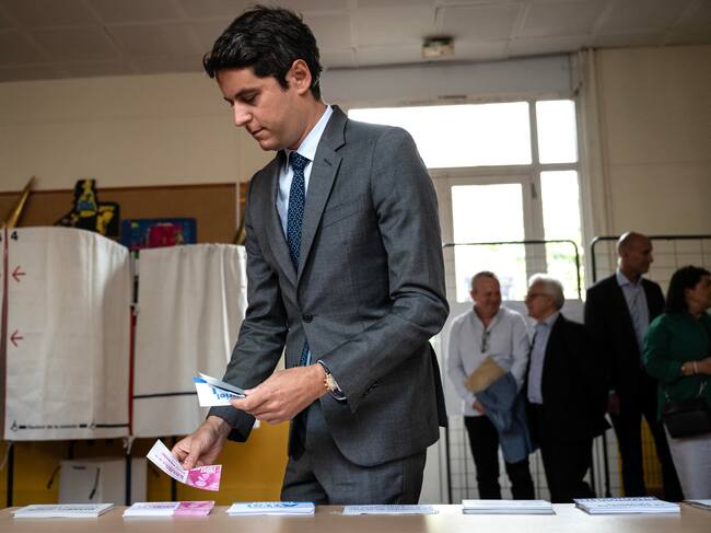 Vanves (France), 30/06/2024.- France's Prime Minister Gabriel Attal (front) takes ballots prior to casting his vote in the first round of parliamentary elections in Vanves, southwestern Paris, France, 30 June 2024. A divided France is voting in high-stakes parliamentary elections that could see the anti-immigrant and eurosceptic party of Marine Le Pen sweep to power in a historic first. The candidates formally ended their frantic campaigns at midnight on 28 June, with political activity banned until the first round of voting. (Elecciones, Francia) EFE/EPA/ARNAUD FINISTRE / POOL MAXPPP OUT