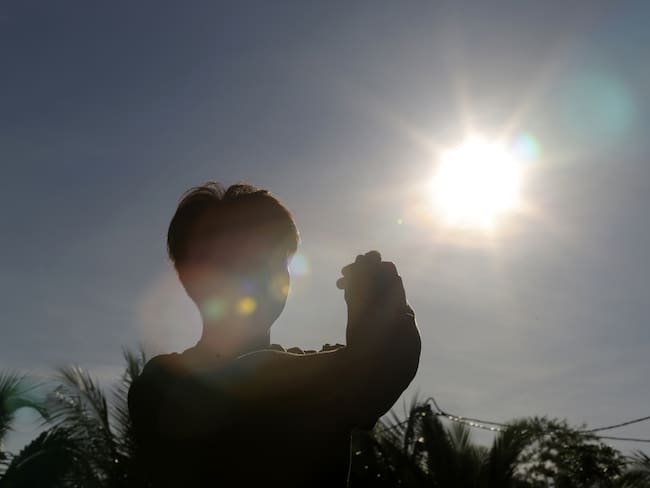 Niño mirando hacia el sol, durante un día completamente despejado (Getty Images)
