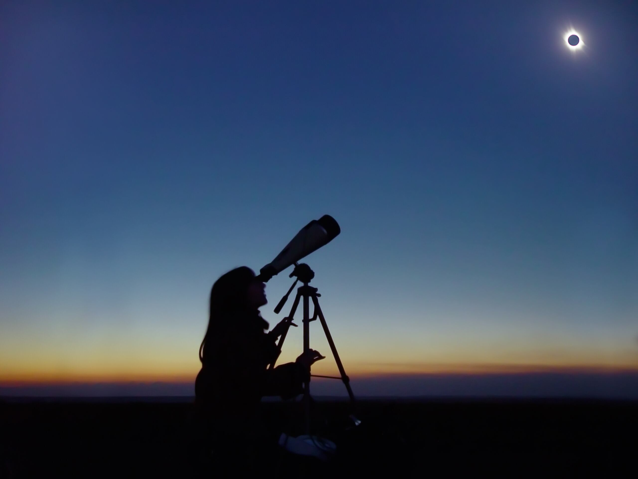 Mujer observando el eclipse solar total a través de un telescopio (Foto vía GettyImages)
