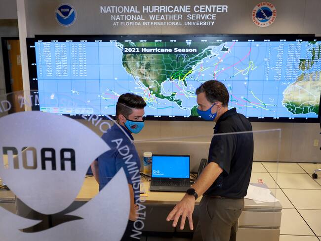MIAMI, FLORIDA - JUNE 01: Robbie Berg (L), Senior Hurricane Specialist, and Jamie Rhome, Deputy Director of NOAA's National Hurricane Center, interact on the floor of the National Hurricane Center on June 01, 2022 in Miami, Florida. As the 2022 Atlantic hurricane season begins, remnants of the former Pacific hurricane Agatha are expected to reform in the Gulf of Mexico, possibly as a tropical storm, in the next five days, according to the National Hurricane Center. (Photo by Joe Raedle/Getty Images)