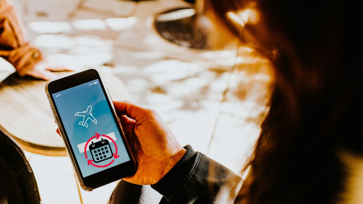 Mujer revisando su celular para reservar el vuelo (Getty Images)