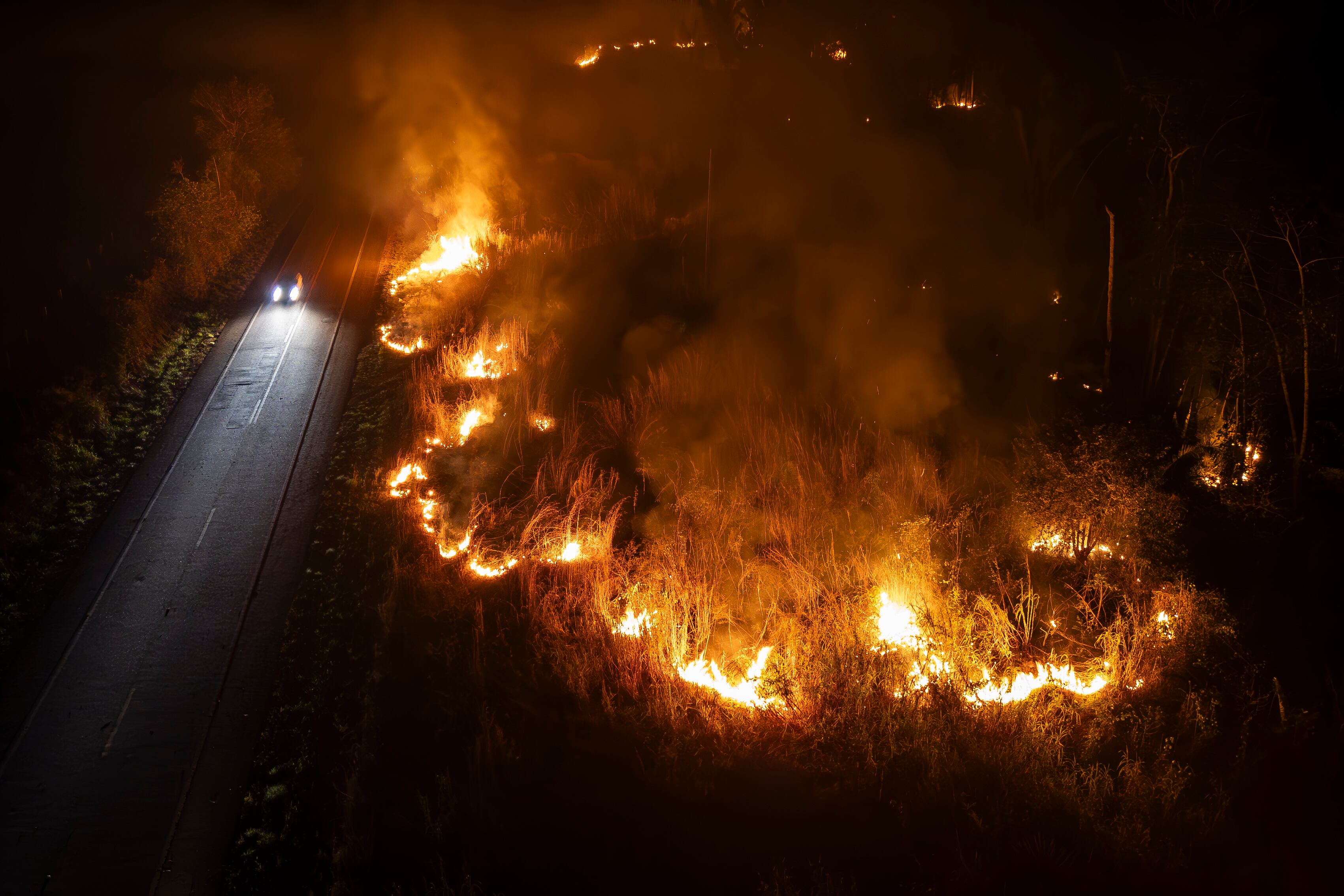 -FOTODELDÍA- BRA100. PORTO VELHO (BRASIL), 13/09/2024.- Fotografía tomada con un dron la noche del jueves 12 de septiembre durante un gran incendio forestal en las orillas de la BR-364 en la ciudad de Porto Velho en el estado de Rondonia. EFE/ Isaac Fontana