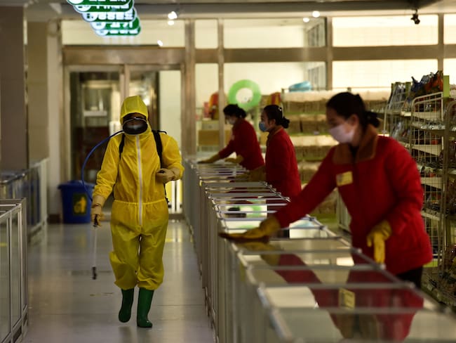 TOPSHOT - Employees spray disinfectant and wipe surfaces as part of preventative measures against the Covid-19 coronavirus at the Pyongyang Children&#039;s Department Store in Pyongyang on March 18, 2022. (Photo by KIM Won Jin / AFP) (Photo by KIM WON JIN/AFP via Getty Images)
